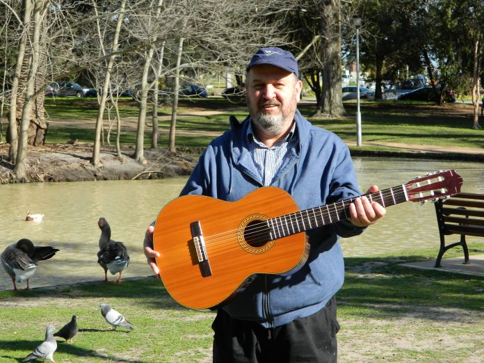 Sam Green With Guitar In Garden